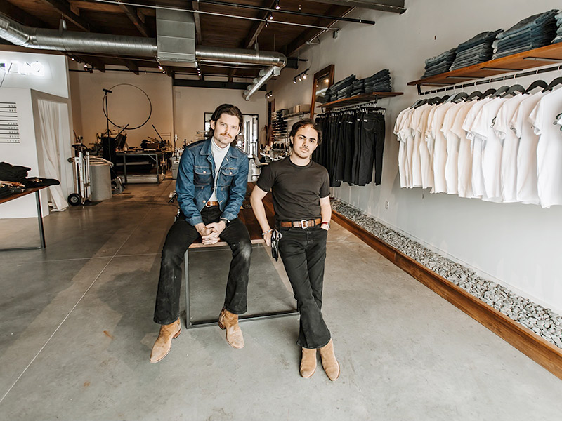 Two man looking at a camera, they are within a clothing store