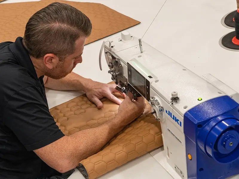 A closeup of a person working on a JUKI machine