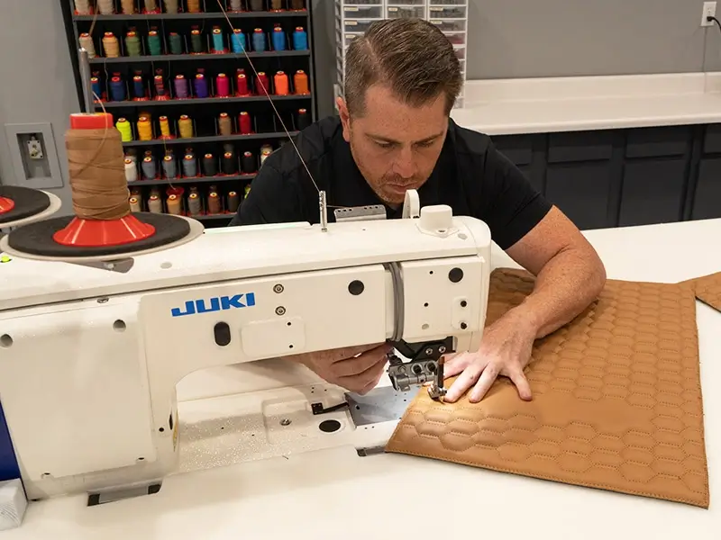 A closeup of a person working on a JUKI machine