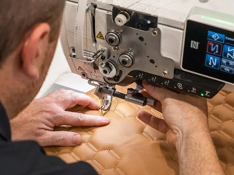 A closeup of a person working on a JUKI machine