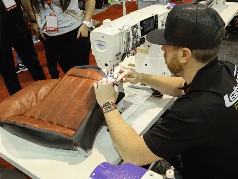 A closeup of a person working on a JUKI machine