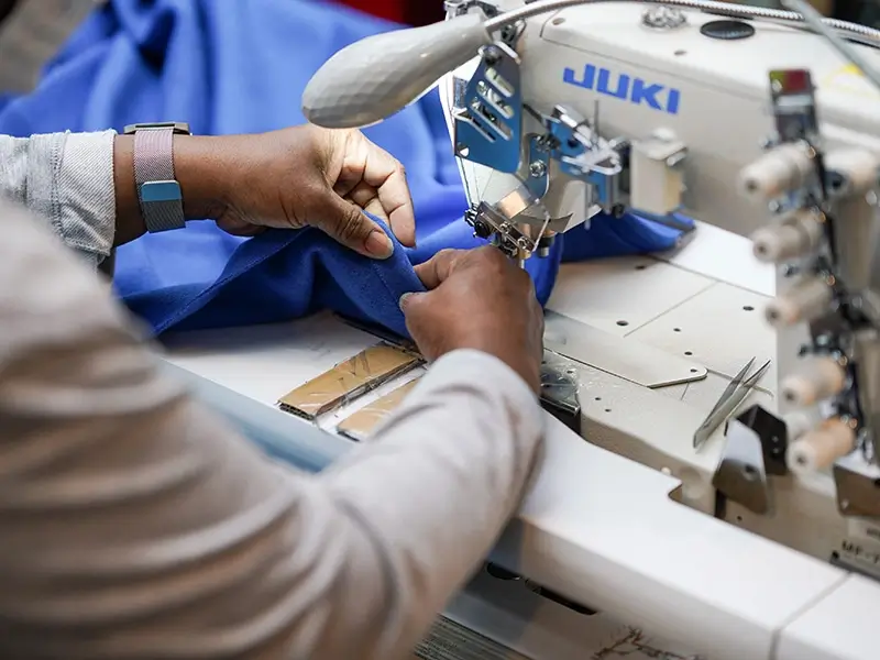 A closeup of a person working on a JUKI machine